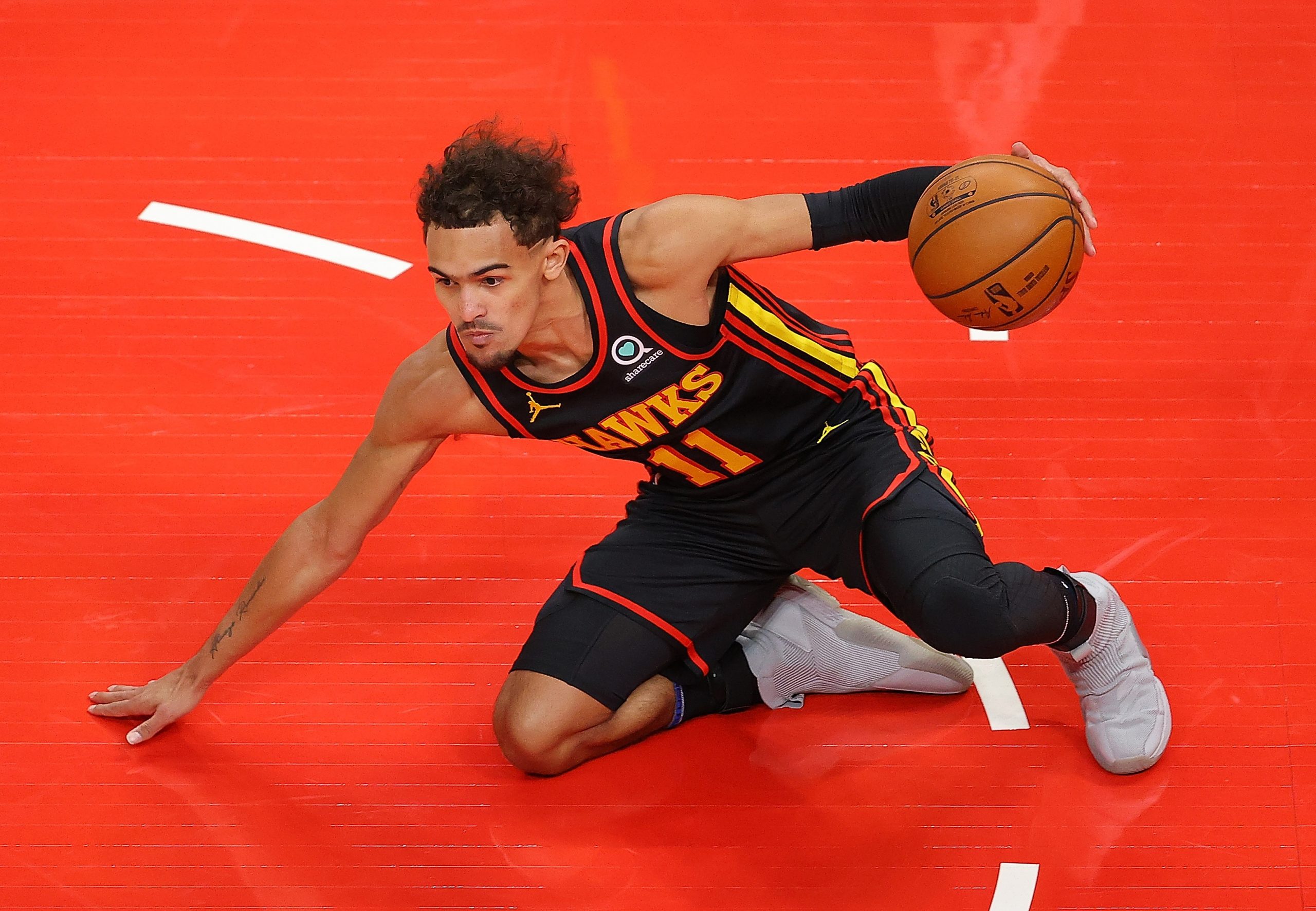 ATLANTA, GEORGIA - FEBRUARY 01:   Trae Young #11 of the Atlanta Hawks slips to the floor as he dribbles against the Los Angeles Lakers during the first half at State Farm Arena on February 01, 2021 in Atlanta, Georgia.  NOTE TO USER: User expressly acknowledges and agrees that, by downloading and or using this photograph, User is consenting to the terms and conditions of the Getty Images License Agreement.  (Photo by Kevin C. Cox/Getty Images)