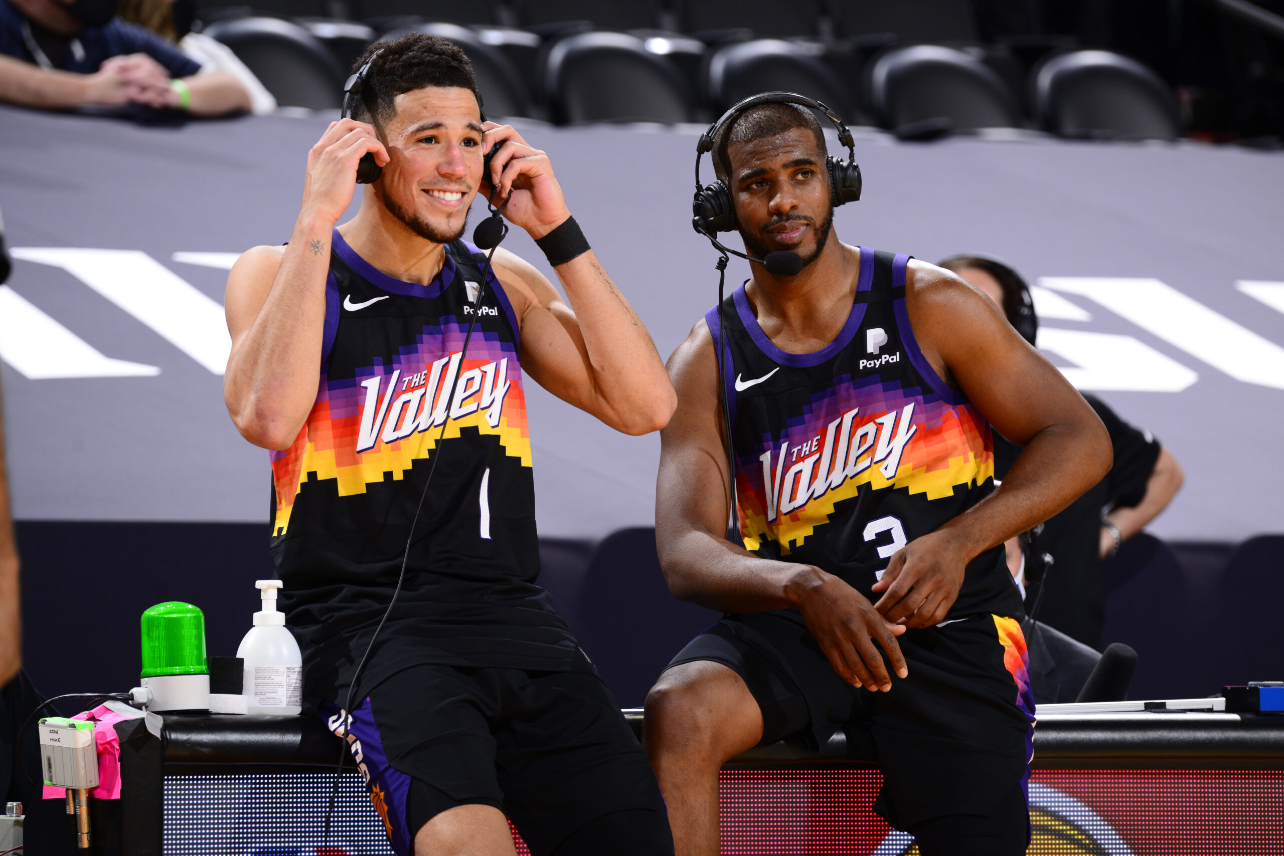 PHOENIX, AZ - APRIL 7: Devin Booker #1 and Chris Paul #3 of the Phoenix Suns get interviewed after the game against the Utah Jazz on April 7, 2021 at Phoenix Suns Arena in Phoenix, Arizona. NOTE TO USER: User expressly acknowledges and agrees that, by downloading and or using this photograph, user is consenting to the terms and conditions of the Getty Images License Agreement. Mandatory Copyright Notice: Copyright 2021 NBAE (Photo by Barry Gossage/NBAE via Getty Images)